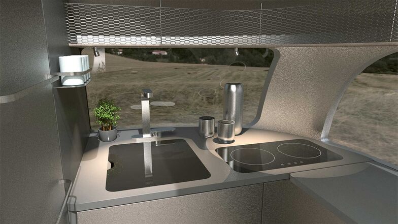 À l’avant, le bloc cuisine compact peut être au besoin transformé en une cuisine en L grâce à un panneau supplémentaire repliable devant la porte d’entrée.